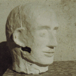 Gipsskulptur eines menschlichen Kopfes mit rauer Oberfläche und Rissen | Plaster sculpture of a human head with rough surface and cracks
