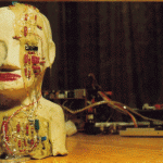 Skulptur eines Menschenkopfes aus Ton mit eingebetteten Elektronikbauteilen und Kabeln | Clay human head sculpture with embedded electronic components and wires