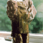 Grob modellierter Tonskulptur-Torso auf Fensterbrett, abstrakte Körperform | Roughly modeled clay sculpture torso on windowsill, abstract body form