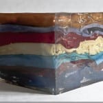 Transparenter Harzblock mit eingegossenen farbigen Stoffschichten in Blau, Rot und Braun | Transparent resin block with embedded colorful fabric layers in blue, red and brown