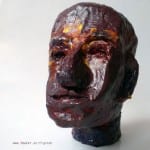 Menschlicher Kopf aus Pappmaché, dunkelrot-braun glasiert mit gelben Farbakzenten | Human head sculpture from papier-mâché, dark red-brown glazed with yellow color accents
