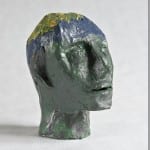 Bemalter Skulpturkopf in Grün und Blau mit gelben Akzenten oben | Painted sculpture head in green and blue with yellow accents on top