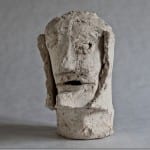 Grobe Tonskulptur eines menschlichen Kopfes mit markanten, abstrahierten Gesichtszügen | Rough clay sculpture of a human head with bold, abstracted facial features