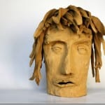 Tonskulptur eines menschlichen Kopfes mit blattartigem Haar, geschlossene Augen | Clay sculpture of a human head with leaf-like hair, closed eyes
