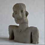 Grobe Tonskulptur einer menschlichen Büste mit markanten Gesichtszügen | Rough clay sculpture of a human bust with distinctive facial features