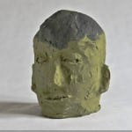Skulptur eines menschlichen Kopfes aus gelbgrüner Ton mit grauem Haar | Sculpture of a human head in yellow-green clay with gray hair