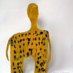 Gelbe abstrakte Menschenfigur mit blauen Flecken, stilisierte Skulptur | Yellow abstract human figure with blue spots, stylized sculpture