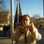 Mann fotografiert sich in Glasscheibe, Weihnachtsbaum und Stadtplatz im Hintergrund | Man photographs himself in glass pane, Christmas tree and town square in background