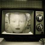Retro-Röhrenfernseher zeigt Schwarzweiß-Kindergesicht mit großen Augen | Retro CRT television displaying black-and-white child's face with wide eyes
