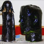 Zwei schwarz glänzende Pappmaché-Skulpturen: schlanke Figur und großer Kopf | Two shiny black papier-mâché sculptures: slender figure and large head