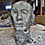 Grau-grüner Tonskulptur-Kopf eines älteren Mannes im Atelier | Grey-green clay sculpture head of an elderly man in an art studio