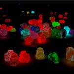 Leuchtende 3D-Objekte in Neonfarben auf schwarzem Grund, digitale Kunst | Glowing 3D objects in neon colors on black background, digital art