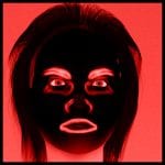 Schwarze Gesichtsmaske mit roten Augen und Lippen vor rotem Hintergrund | Black face mask with red eyes and lips against red background