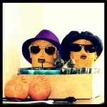 Zwei Tonköpfe mit Sonnenbrillen und Hüten in Pappkarton, davor zwei Keramikköpfe mit Sternen | Two clay heads with sunglasses and hats in cardboard box, two ceramic heads with stars in front