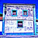 Verfallene Hausfassade mit türkisfarbenen Fensterrahmen, psychedelisch blau eingefärbt | Decayed house facade with turquoise window frames, psychedelically colorized in blue