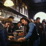 Belebte Bar der 1970er Jahre, Männer mit langen Haaren an dunkler Theke mit Biergläsern | Busy 1970s bar, long-haired men at dark counter with beer glasses and bottle-lined shelves